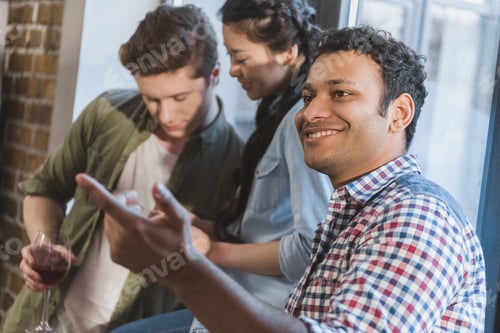 Preview: young people having fun together, conversing and using digital tablet
