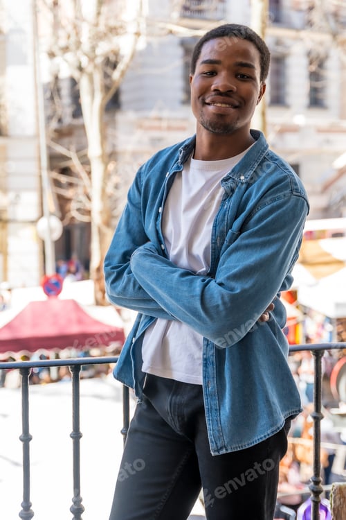 Preview: Portrait of young black ethnic woman at balcony railing at home in the city, lifestyle, smiling