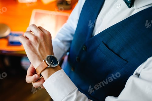 Preview: A man in a shirt adjusts the watch on his arm. Close up of businessman using watch. flat lay. top