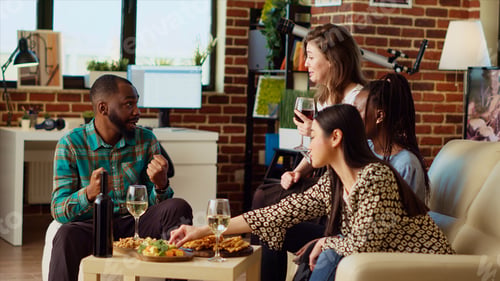 Preview: Merry guests laughing in modern living room after gifting host presents