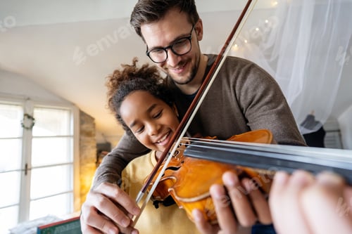 Preview: Young man musician teaching a teen girl to play violin. Education music instrument happiness concept