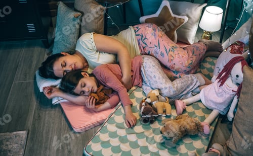 Preview: Mother embracing to little daughter asleep at night. Security and family protection concept.