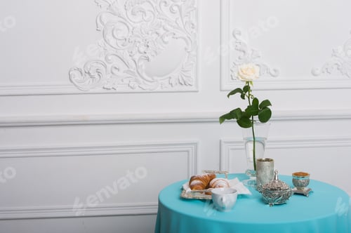 Preview: croissant and white rose on a table against luxury wall, copy space