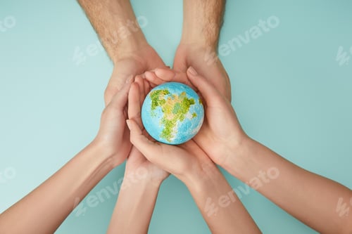 Preview: top view of man and woman holding planet model on turquoise background, earth day concept