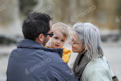 Preview: Gray-haired grandmother with a son and grandson on a walk