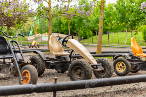 Preview: Colorful go-karts sit idle in a well-maintained park, surrounded by lush greenery