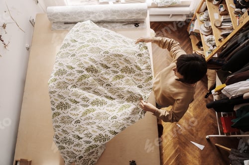 Preview: Creative seamstress in her craft workshop with fabrics