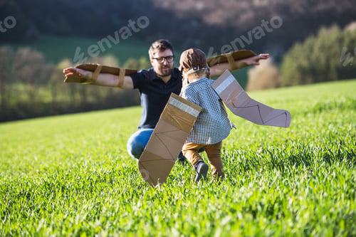 Preview: Happy toddler boy playing outside with father in spring nature.