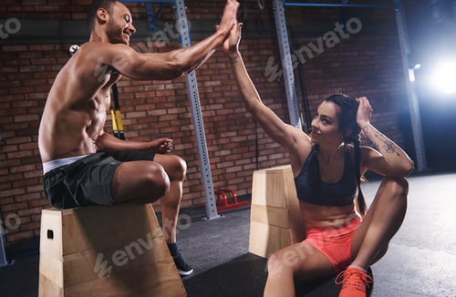 Preview: Sporty couple high five at gym