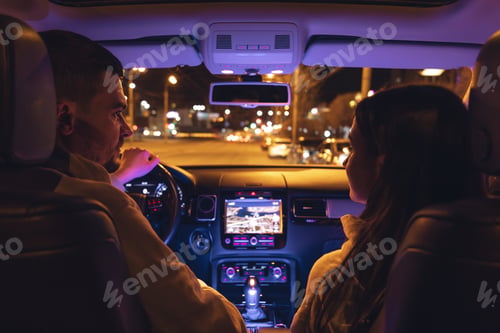 Preview: Man and woman in a car at night, view from the car.