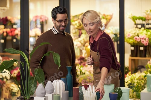 Preview: Caucasian Middle Aged Woman Assisting Young Adult Man Choosing Flowers