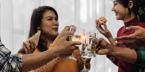 Preview: Cheers Young happy friends are toasting at the party at home. All wearing casual clothes and having