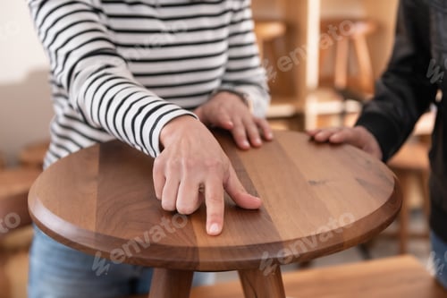 Preview: Interior decorator choosing furniture, holding a wooden chair