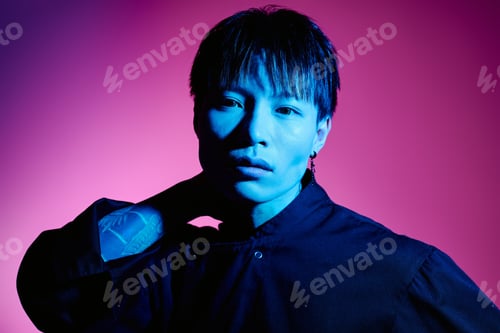 Preview: Stylish young asian man poses confidently against vibrant colored backdrop