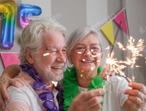 Preview: Two cheerful Caucasian seniors celebrating 75th birthday with sparkles