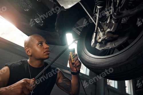 Preview: Concentrated car mechanic checking condition of wheels and axle