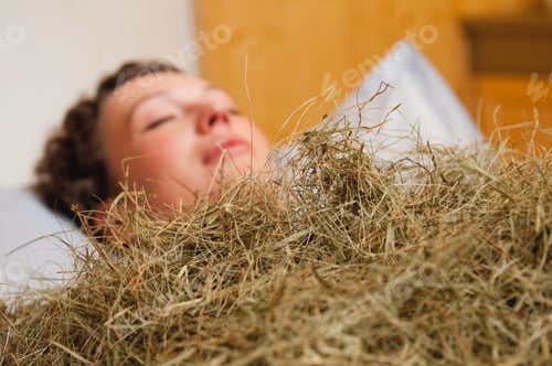 Preview: Italy, South Tyrol, Woman having hay bath in hotel urthaler