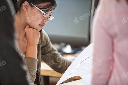 Preview: Asian woman leading an informal meeting in a creative office.