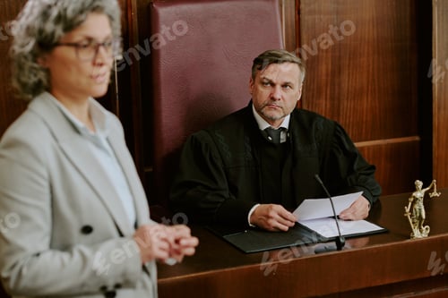 Preview: Middle Aged Caucasian Male Judge Listening to Female Lawyer in Courtroom