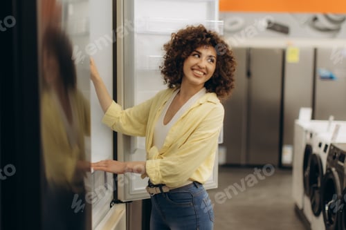 Preview: Smiling Woman Exploring Appliances in Modern Electronics Store