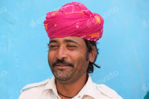Preview: Portrait of a mid-aged Indian man with a traditional pagri against a blue wall