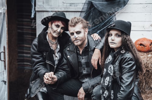 Preview: Scary family, mother, father, daughters celebrating halloween. Terrifying black skull half-face make