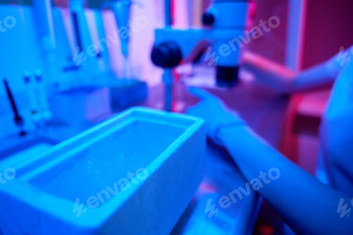 Preview: Female laboratory assistant at the workplace uses a powerful microscope