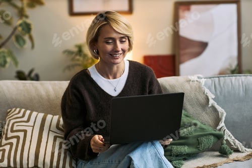 Preview: Woman Working on Laptop While Sitting on Couch