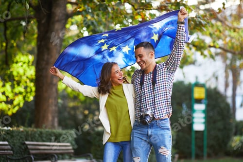 Preview: Happy young couple of tourists with a European Union flag