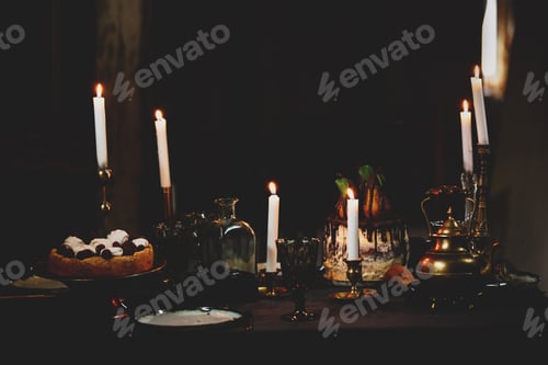 Preview: Cake with raspberry and meringue on a table with candles at dinner time