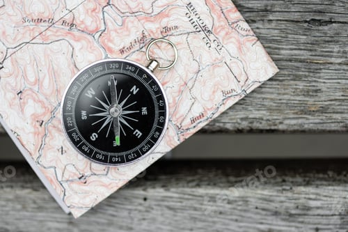 Preview: Compass and map on a beautiful wooden surface. Top view