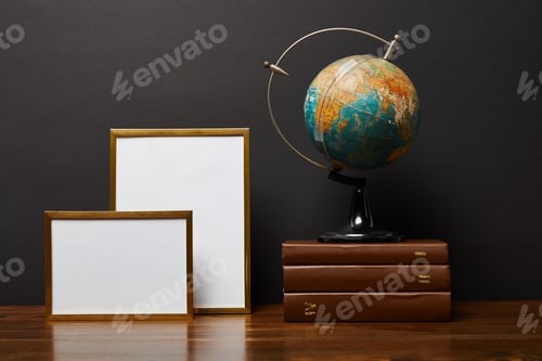 Preview: globe on books near blank frames on table