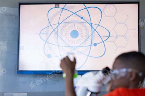 Preview: In school, student using microscope in science classroom, focusing on experiment