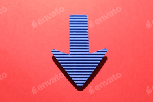 Preview: One blue paper arrow on red background, top view
