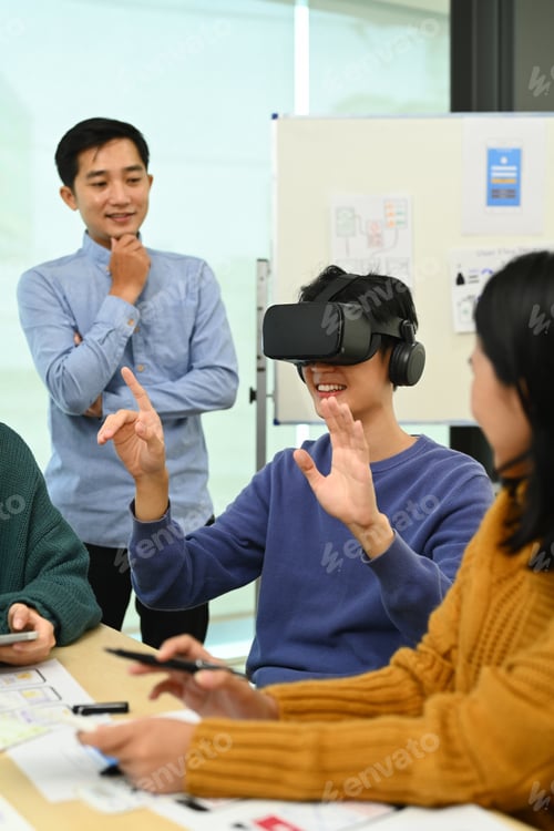 Preview: Young Creative man wearing VR headset, start up team discussing about new digital projects.
