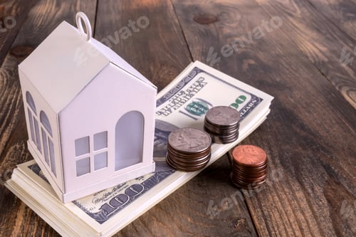Preview: Mortgage or home ownership investment concept. Money and white toy house on table.