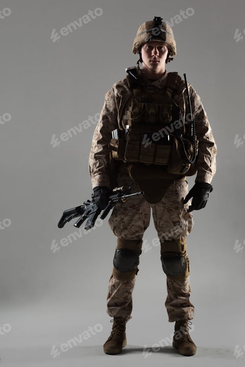 Preview: Soldier stands with weapon in neutral background during military training session