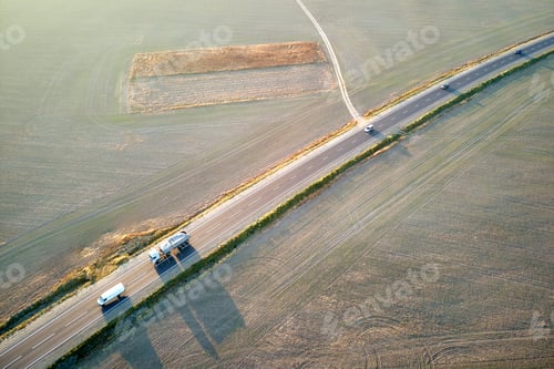 Preview: Aerial view of cargo trucks driving on highway hauling goods. Delivery transportation and logistics