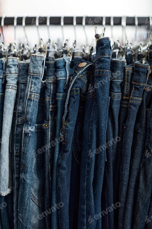 Preview: Blue denim jeans in row on clothing rack