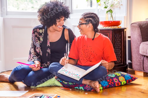 Preview: Mature woman and son doing homework on living room floor