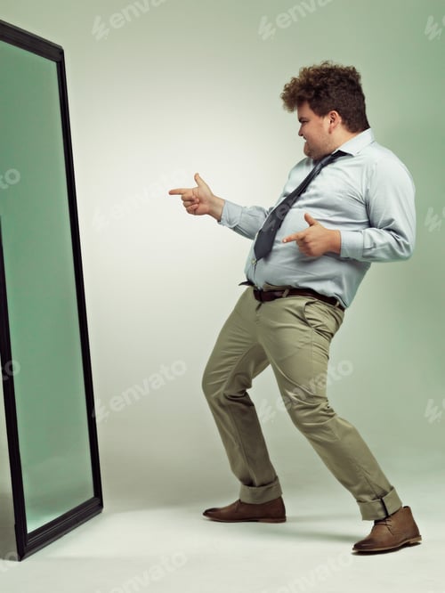 Preview: Im too sexy. Shot of an excited overweight man celebrating while looking in a mirror.