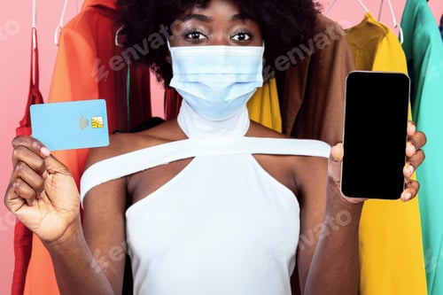 Preview: Woman Showing Phone And Credit Card Wearing Face Mask, Studio