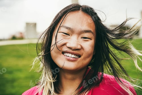 Preview: Asian girl smiling on camera at city park - Focus on face