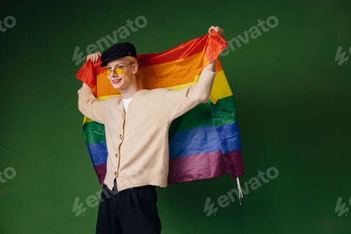 Preview: Studio photo of a man with rainbow flag isolated on green background