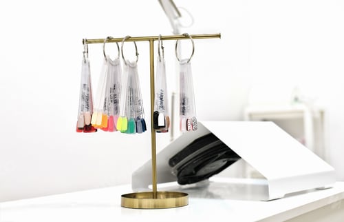Preview: color palette of gel polish colors on a t-stand in beauty salon.