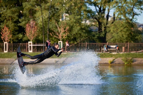Preview: Young surfer having fun wakeboarding in the cable park.