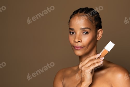 Preview: Makeup product recommendation. Beautiful black middle aged woman holding foundation makeup bottle