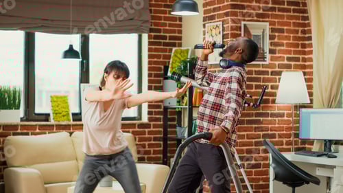 Preview: Interracial partners having fun cleaning room with vacuum cleaner and mop