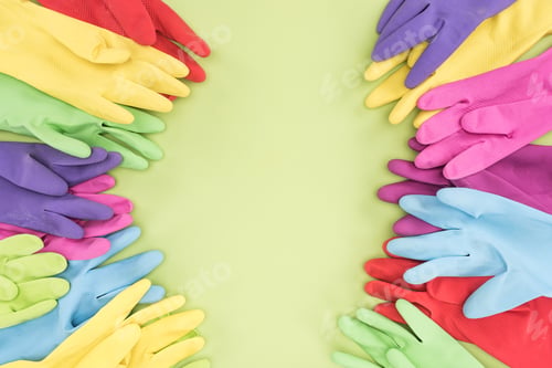 Preview: top view of multicolored rubber gloves on green background with copy space
