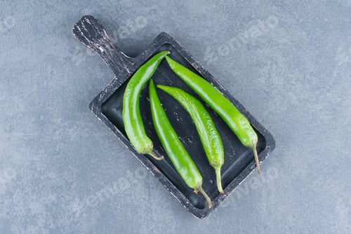 Preview: Green chili peppers on wooden board